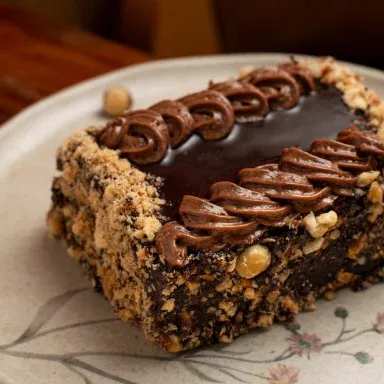 Fatia de bolo Leningrado com chocolate e avelãs
